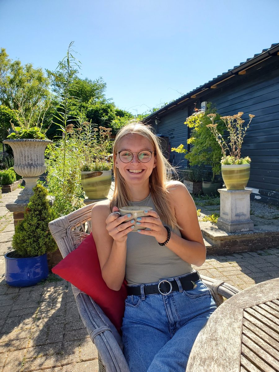 Ashleigh Torrance smiling, holding a mug in a sunny garden
